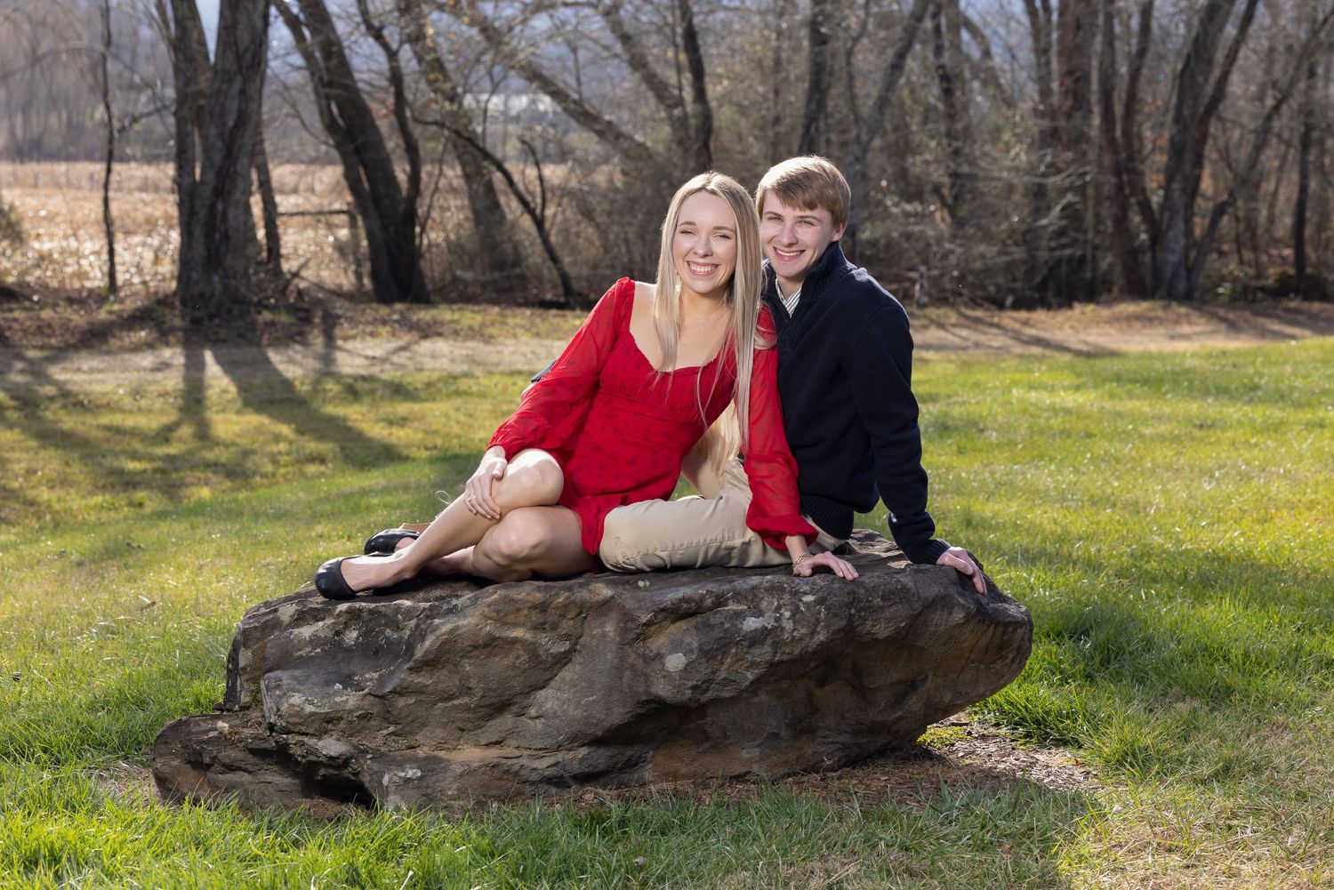 Romantic outdoor photoshoot in a natural wooded setting during golden hour.