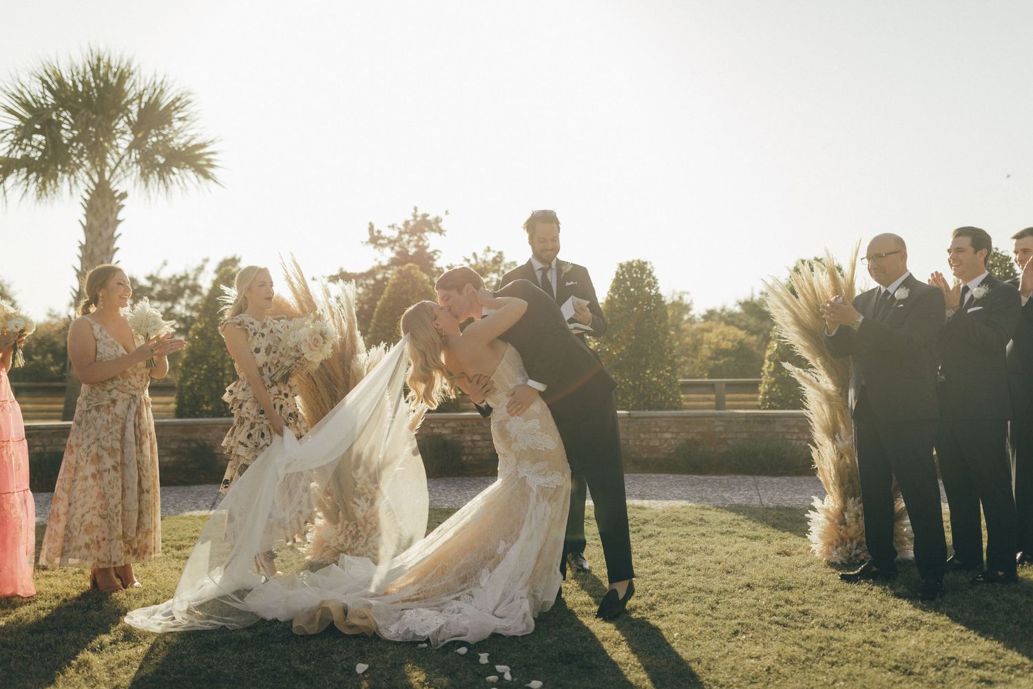 Bride and groom's first kiss at altar with dried pampas grass decor
