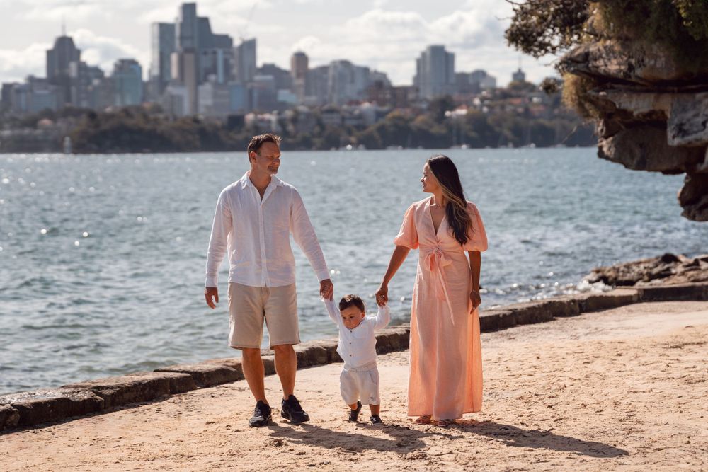 family is walking towards camera during a photoshoot at the beach