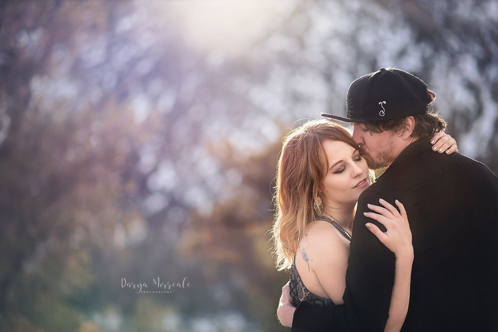 Dreamy winter portrait of couple in intimate embrace with soft bokeh background.