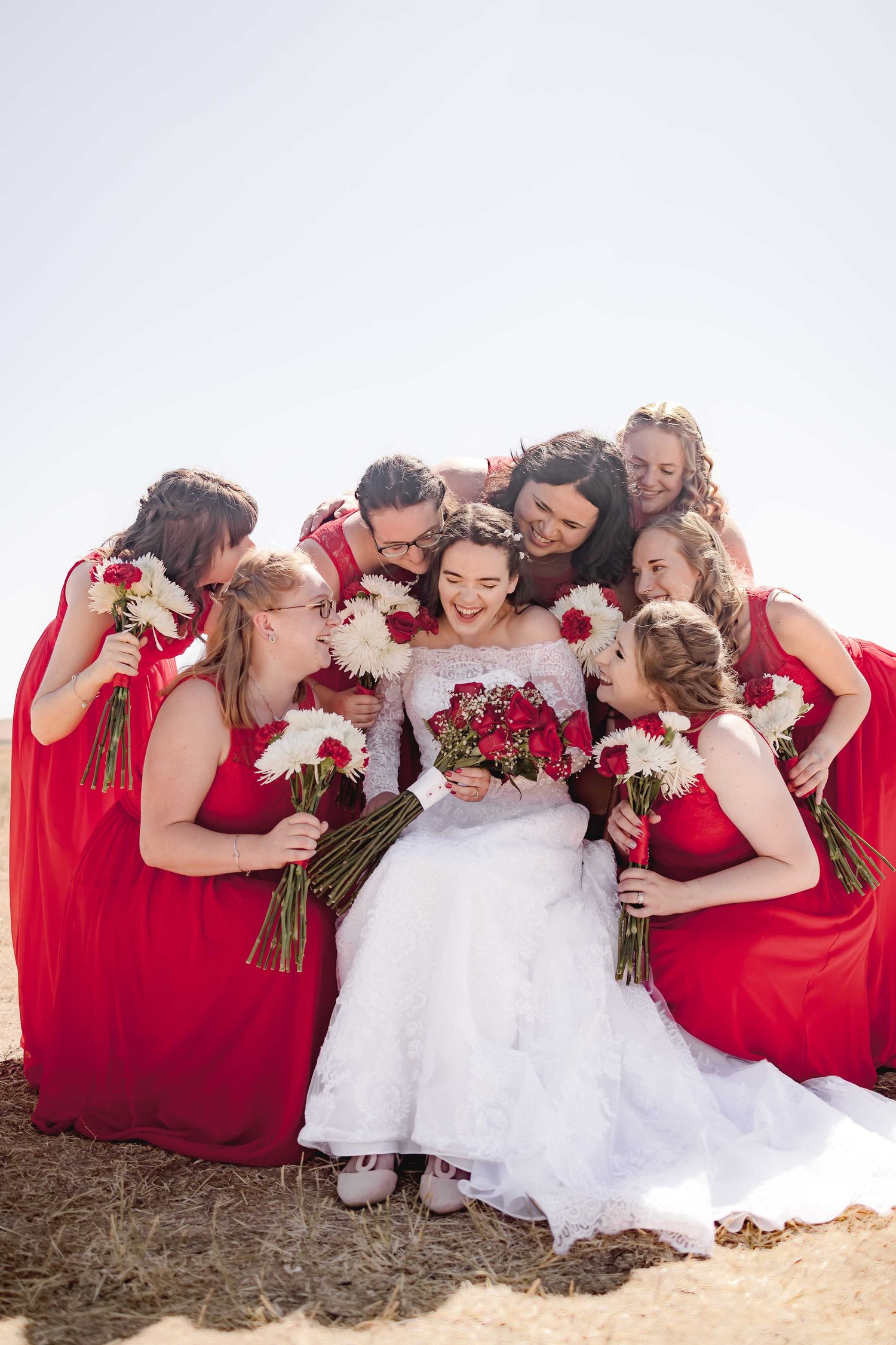 Bride surrounded by her bridesmaids in complete happiness on her wedding day