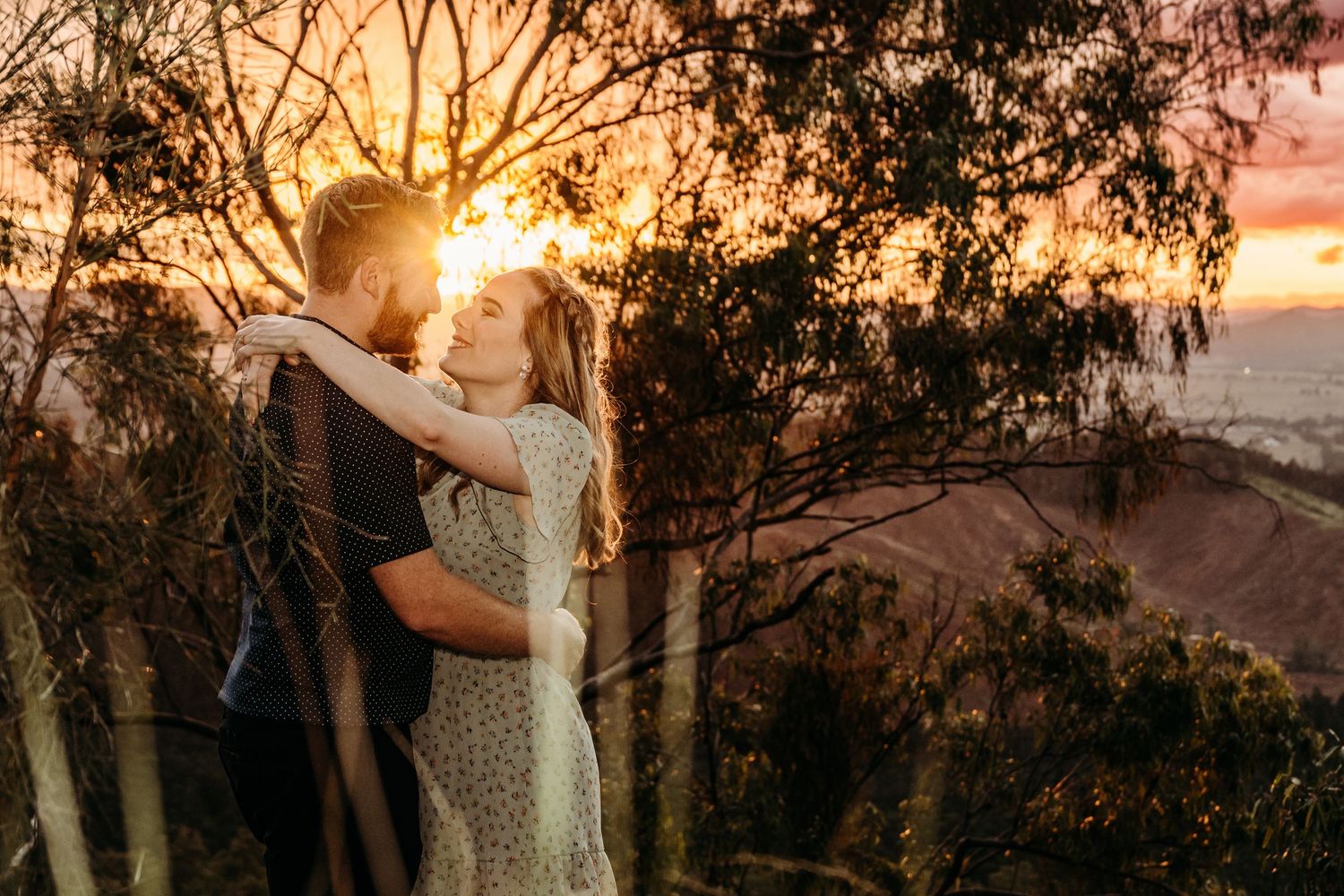 Sunsetsilhouettes through eucalyptus trees frame an intimate moment.