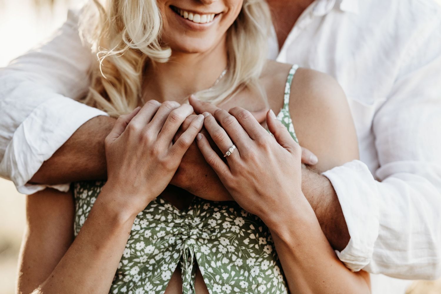 Close up of embracing couple wearing white and floral print clothing.