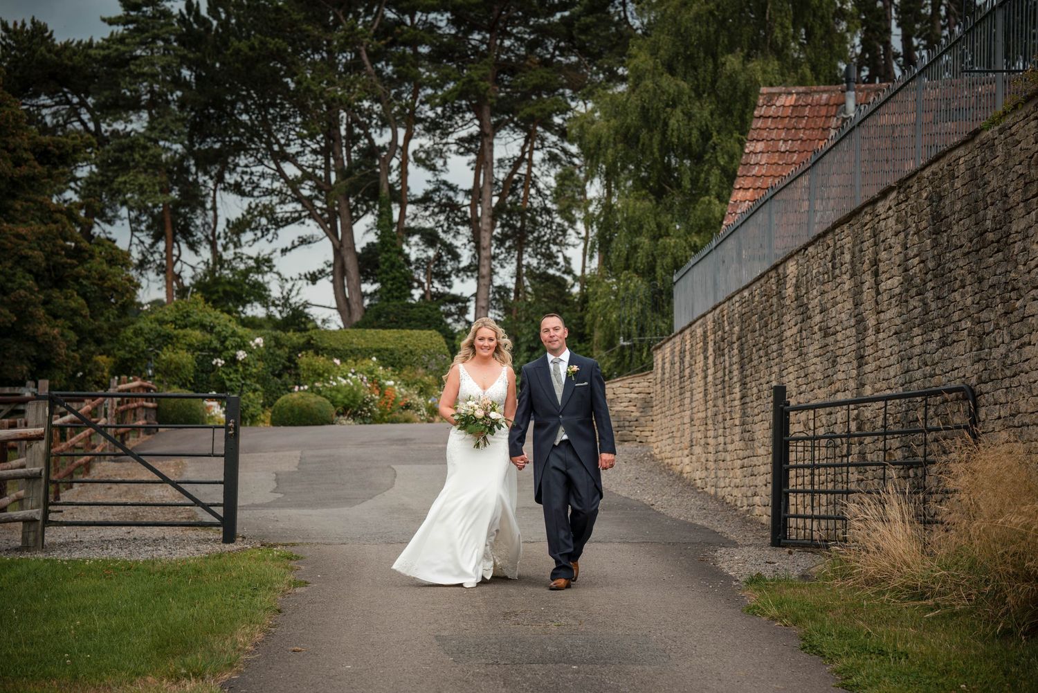 Zara Davis Wedding Photography Kingscote Barn Cotswolds Gloucestershire bride and groom at back of barn gate