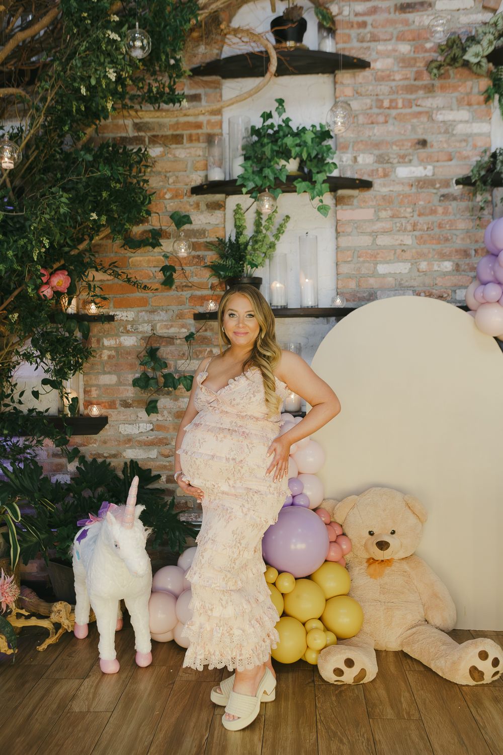 Lovely moment of the mom-to-be showcasing her pregnancy glow in front of the charming decor setup at her baby shower