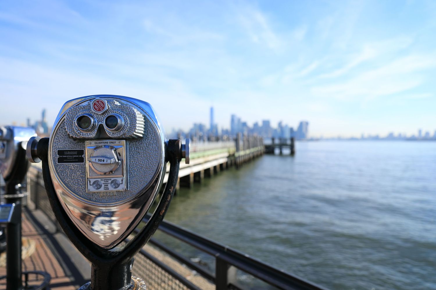 Coin-operated binoculars overlooking the Manhattan skyline across the water.