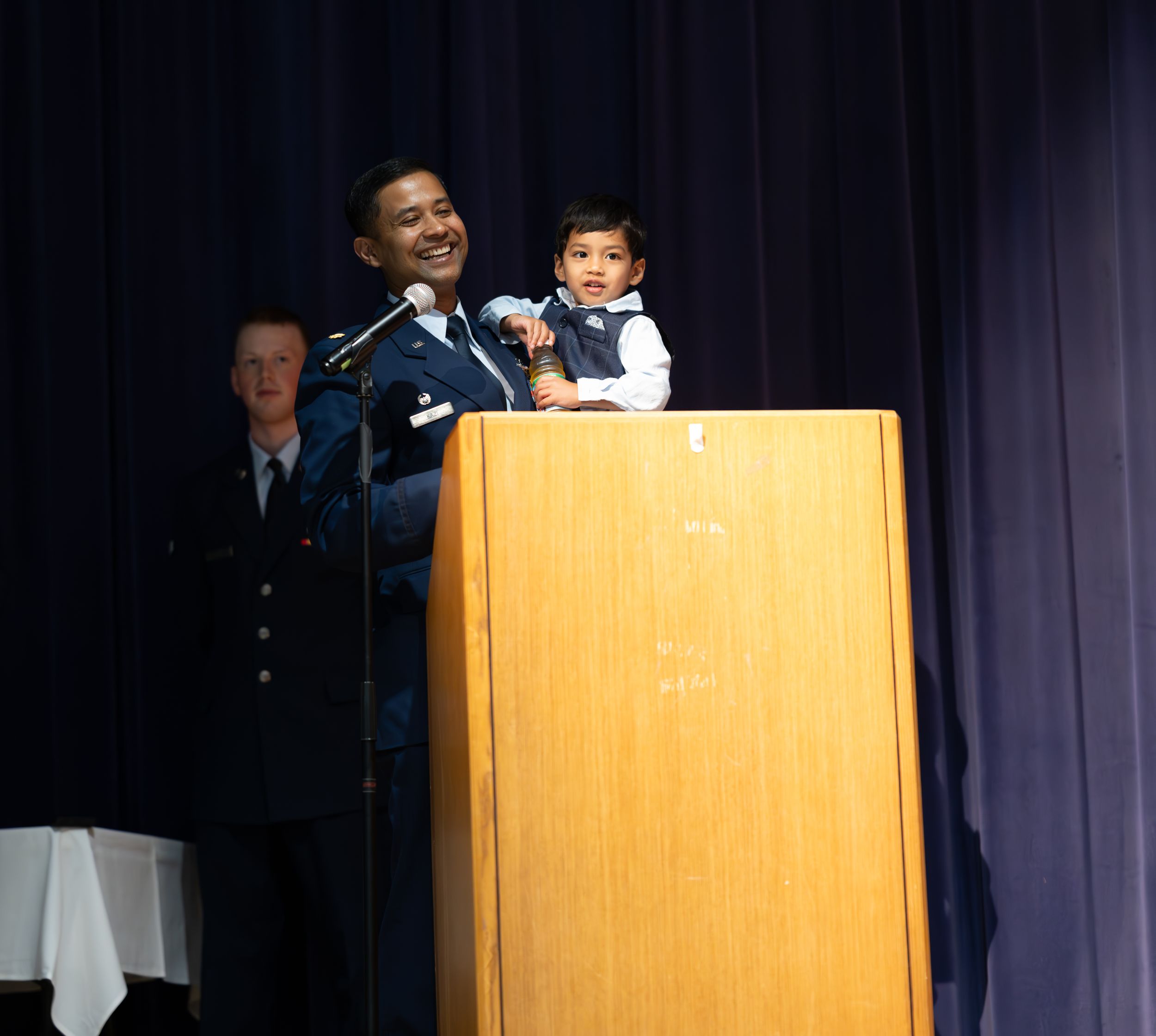 A military ceremony presentation at a podium during a special event.