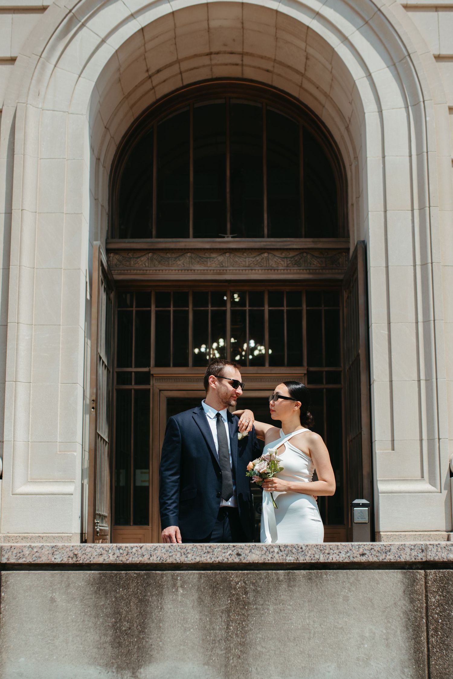 A playful wedding moment captured in an architectural archway.