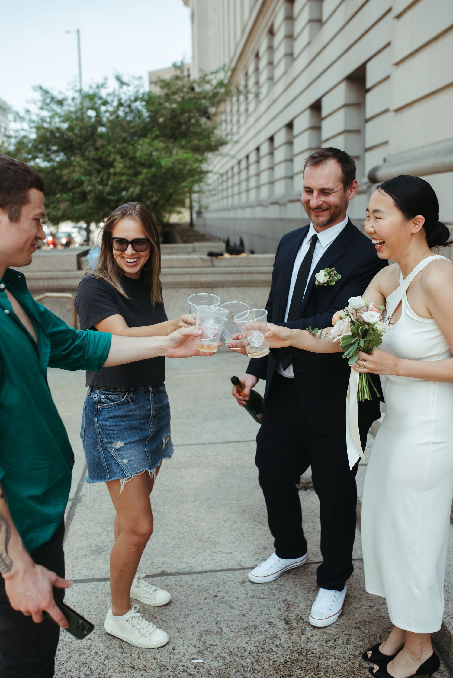 Friends gather outside to toast and celebrate with the newlyweds on their wedding day.