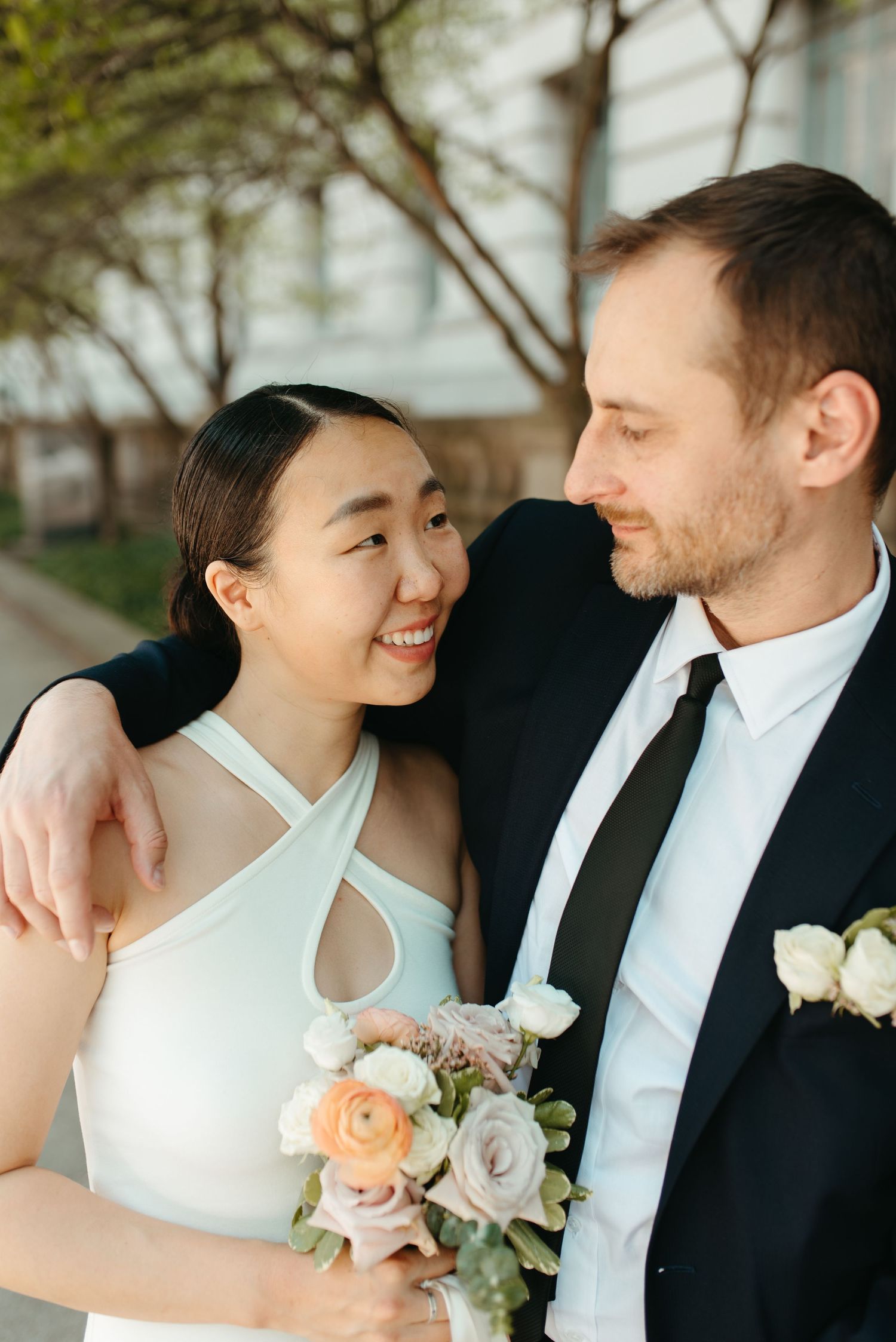 An intimate moment between newlyweds as they share a loving glance outdoors.
