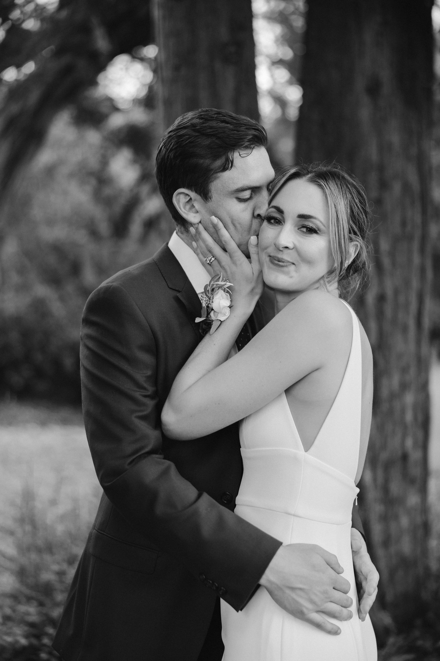 Black and white portrait of wedding couple sharing an intimate embrace outdoors.
