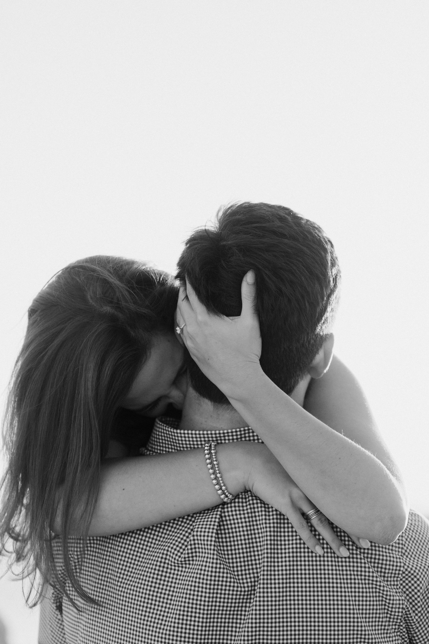 An intimate black and white photo of a romantic couple embracing with passion.