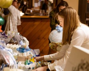Person selecting items from a decorated table at a special event.
