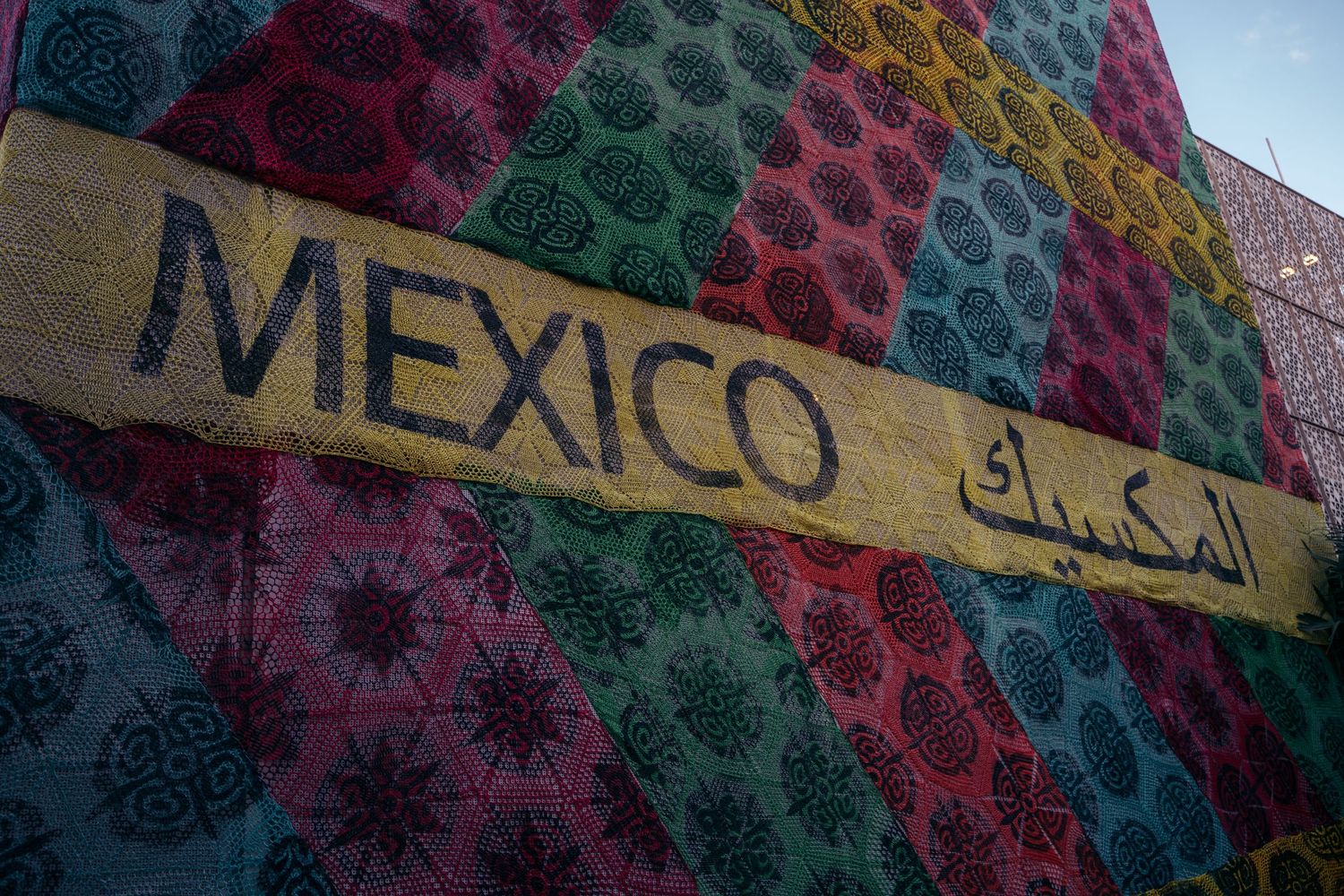 Colorful Mexico pavilion sign with Arabic text on vibrant patterned textile background at Expo 2020.