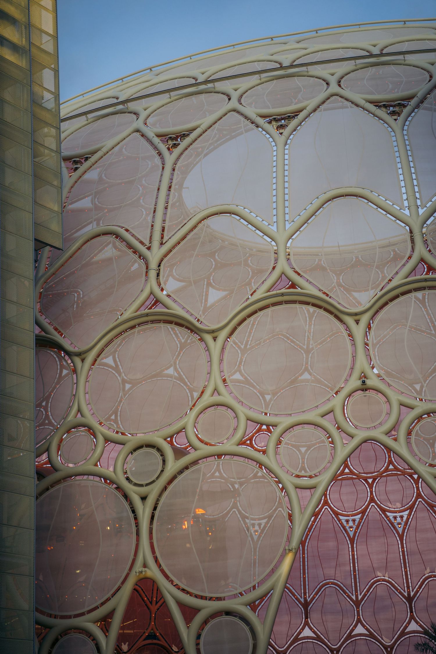 Close-up of intricate pink and beige circular bubble pattern architectural facade detail.