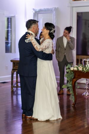 First dance moment captured at indoor wedding reception on hardwood floor.