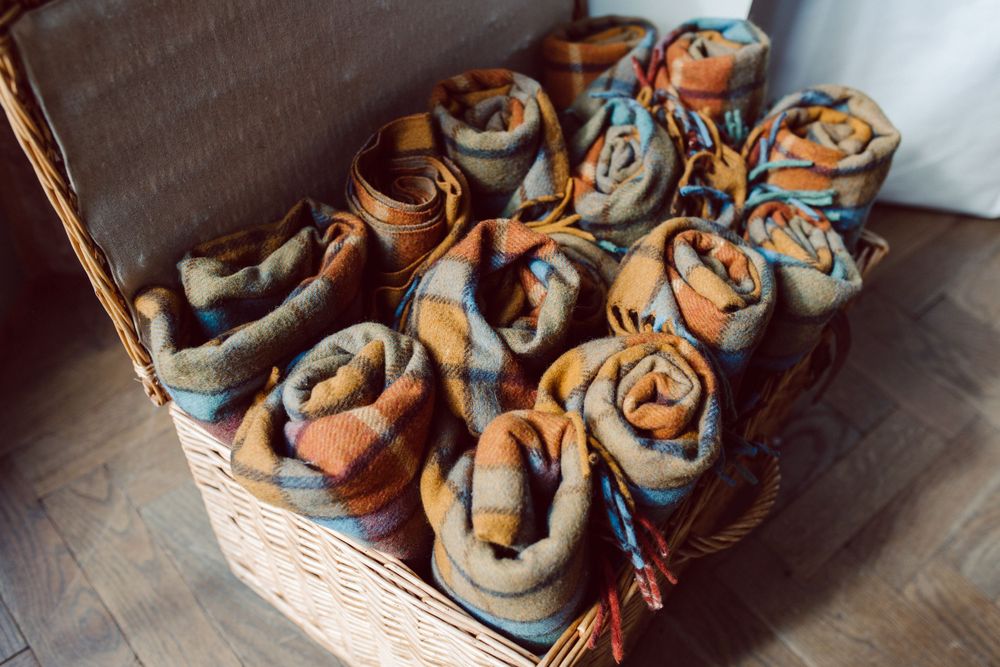 Artfully arranged bread rolls in woven baskets displayed on a rustic wooden surface.