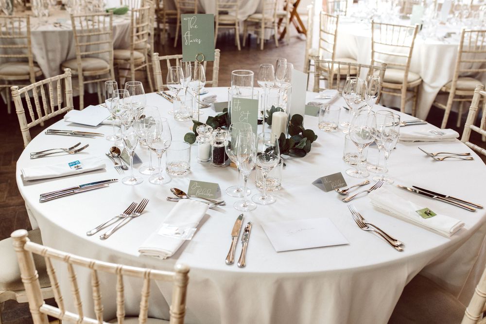 Elegant wedding reception tables set with white linens and place settings.