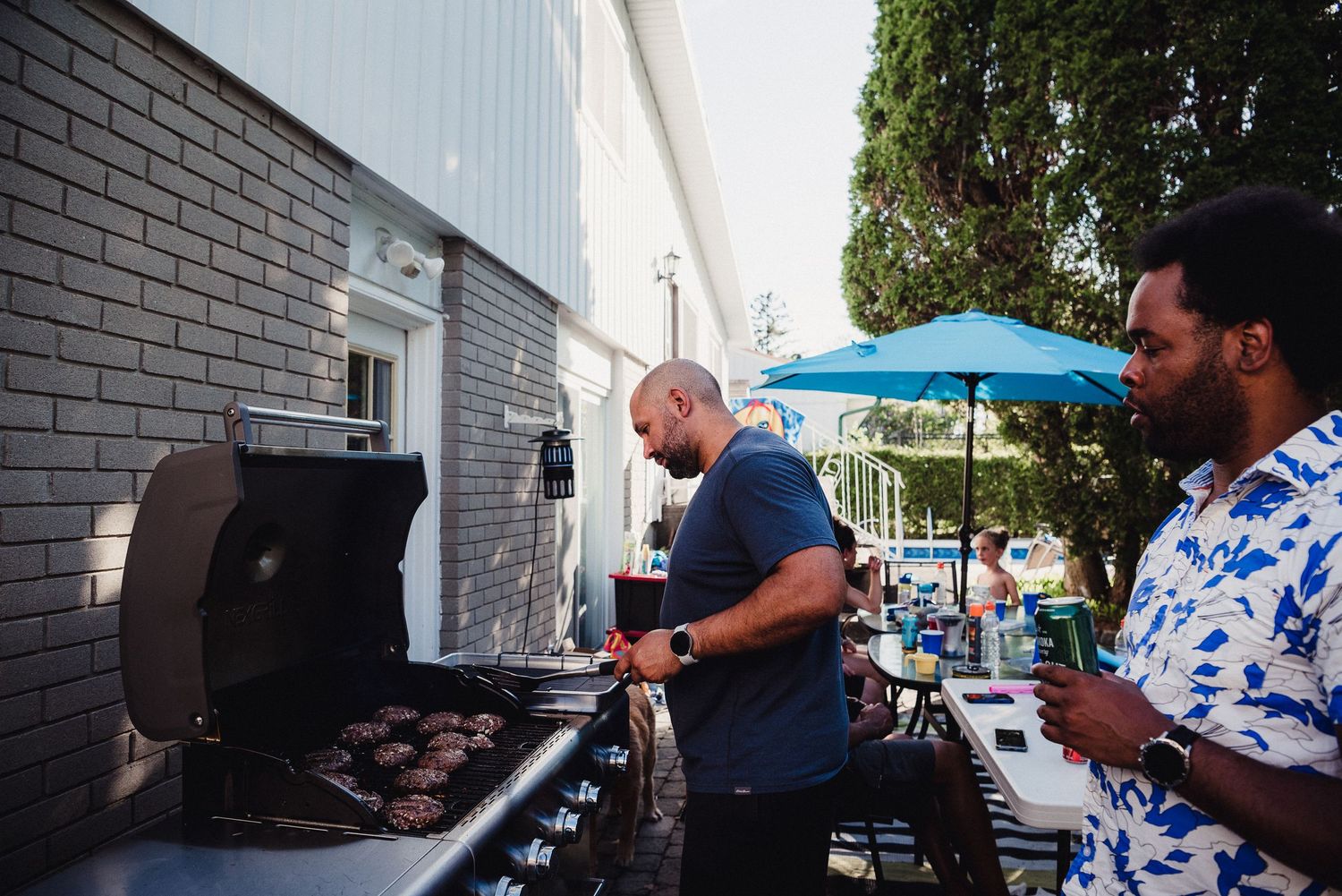 A man bbqs at a family gathering on a summer afternoon.