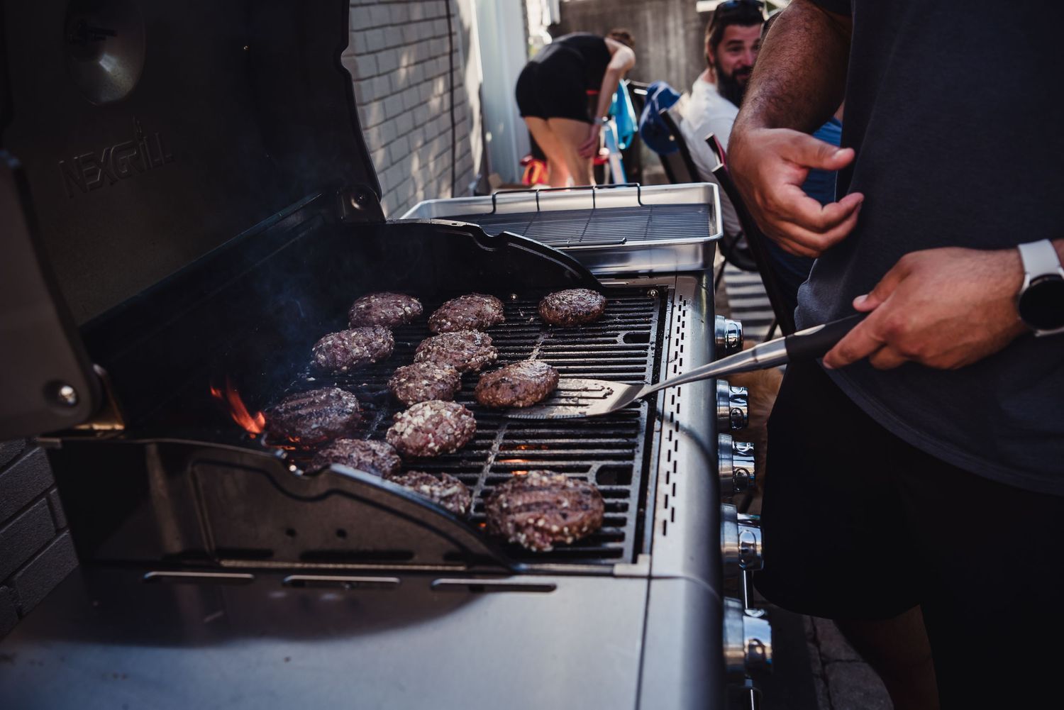 Hamburgers on the bbq being grilled.