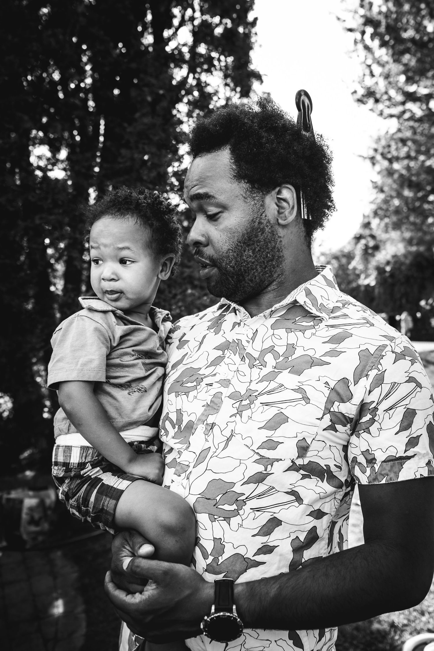 BW image of a black man holding his young son.