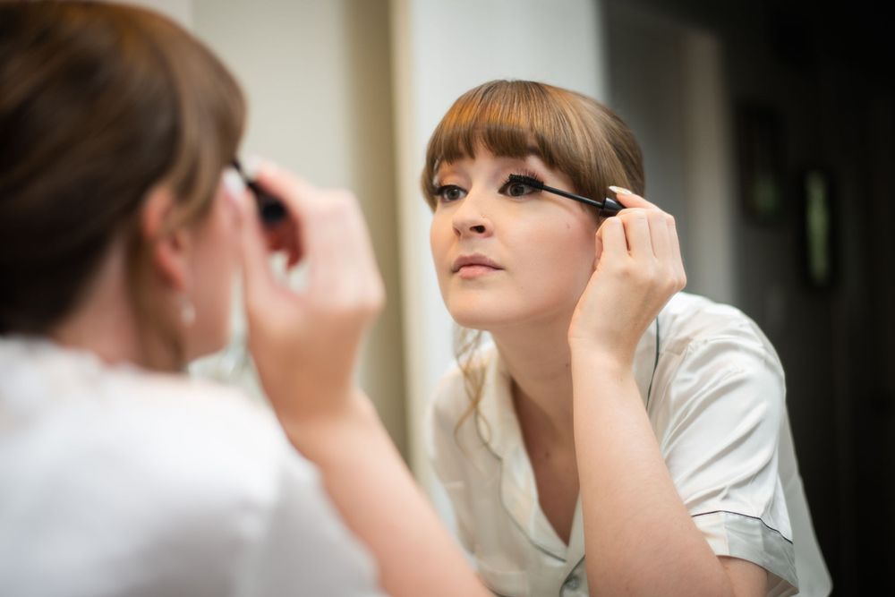 bride getting ready applying makeup for wedding day