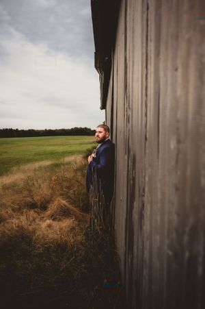 Rustic barn wedding photo shoot with soft lighting and natural landscape.