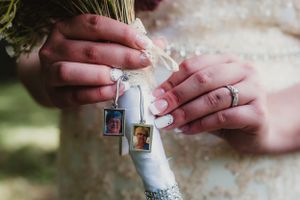Wedding rings hanging from delicate ribbons against a soft background.