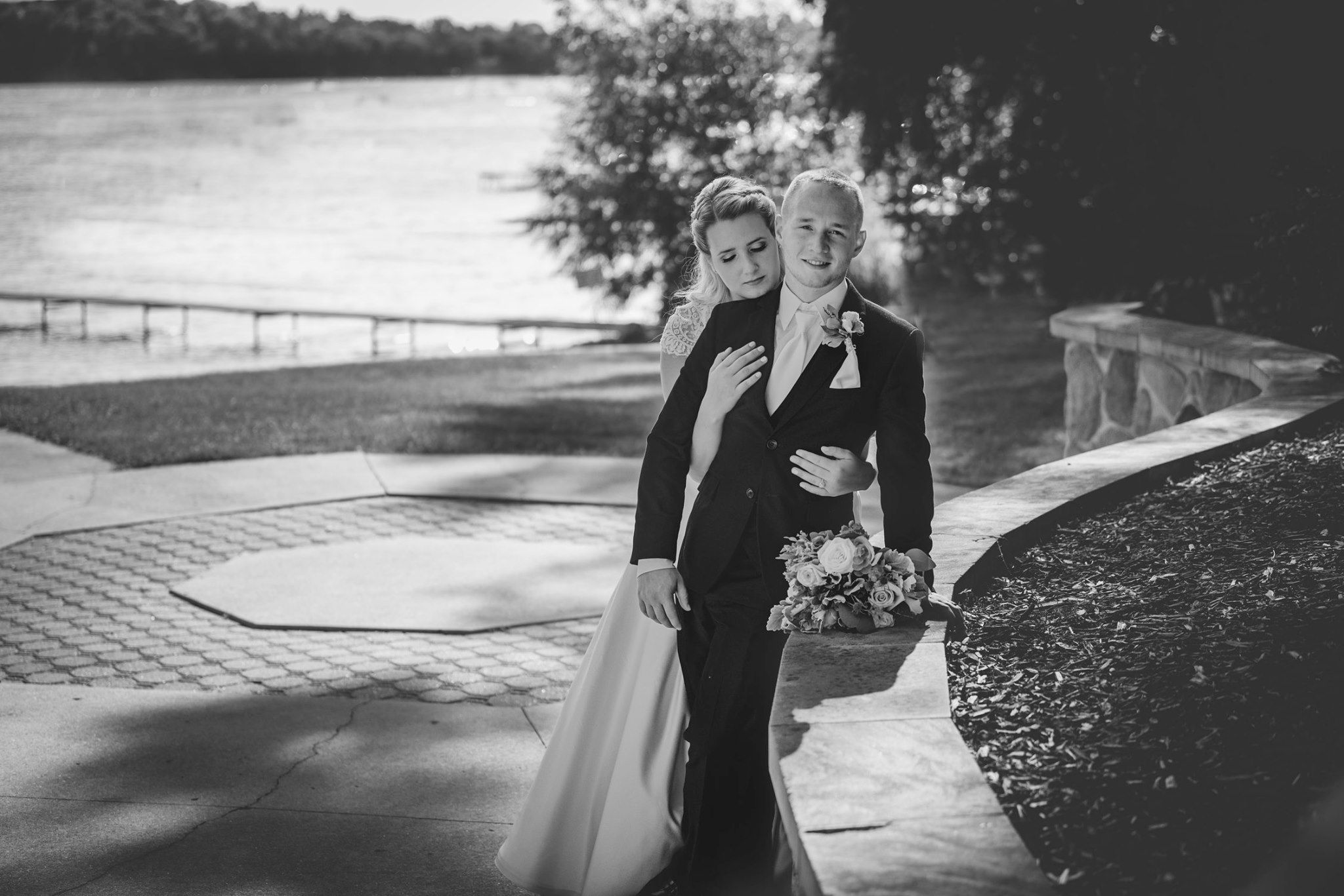 Black and white photos of a couple walking along a waterfront path.