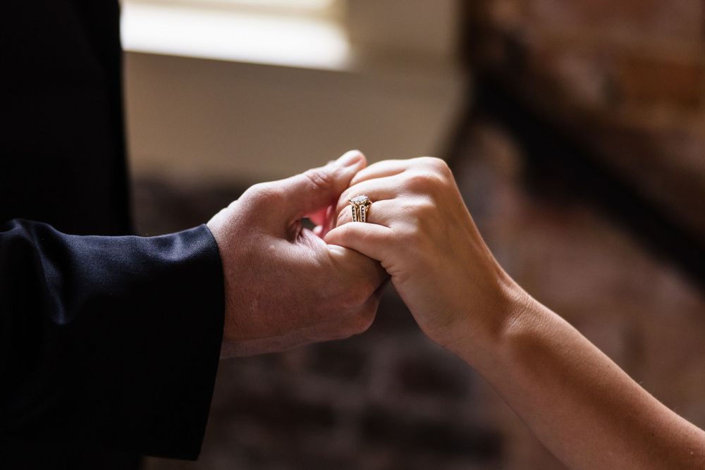 Close-up shot of hands exchanging wedding rings during a ceremony.