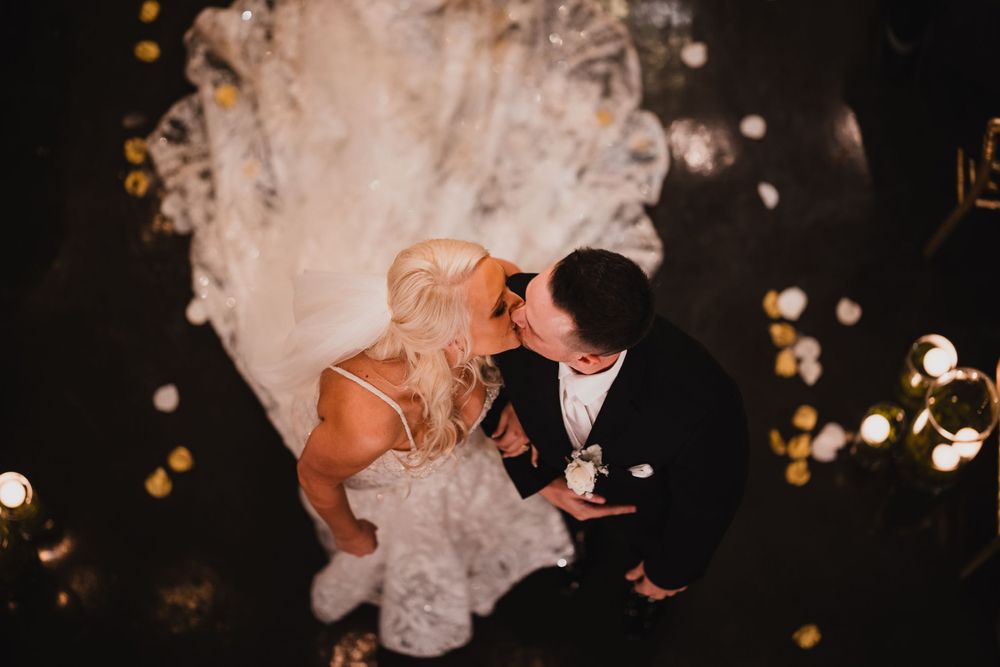 Romantic evening wedding portrait with soft bokeh lights in the background.