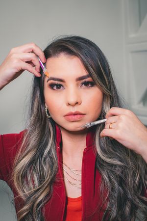 Stylish portrait showing grey highlighted hair and red blazer during beauty treatment.