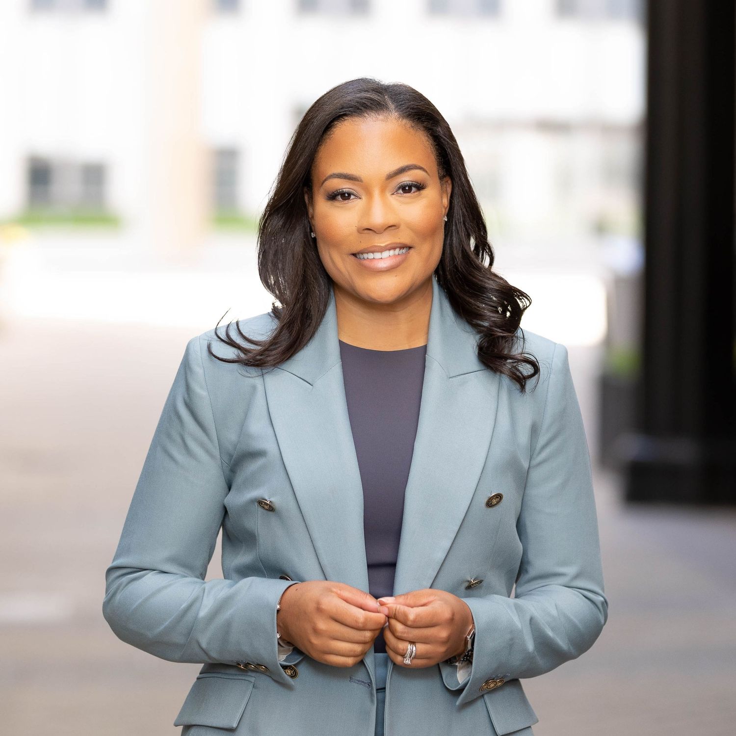 Black woman smiling in pale blue suit