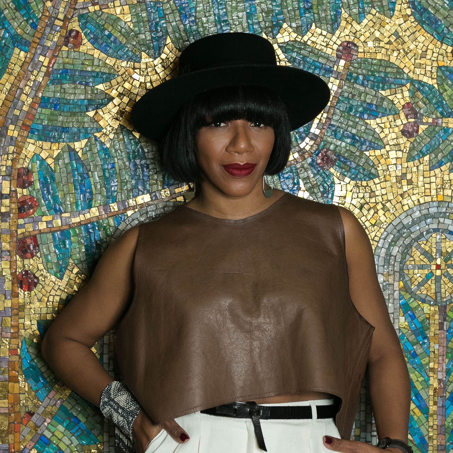 Portrait of a fashionable black woman against a colorful mosaic.