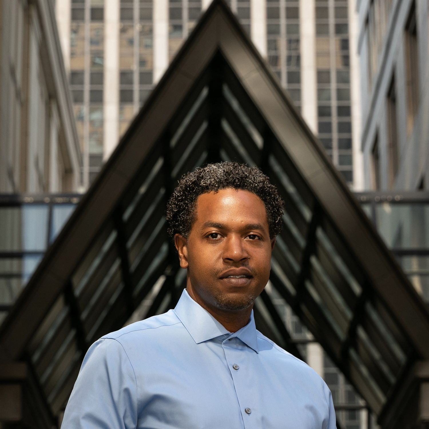 Portrait of a Black man in front of pyramid structure
