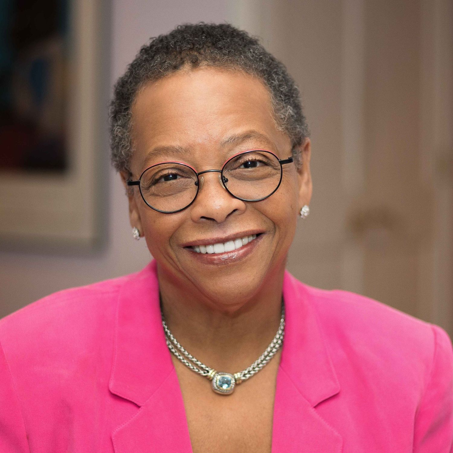 Headshot of a smiling black woman in casual business attire.