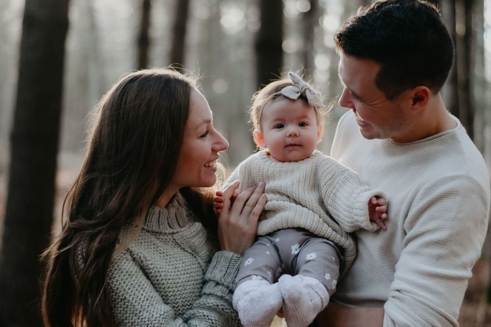 A family moment captured in a misty forest setting.