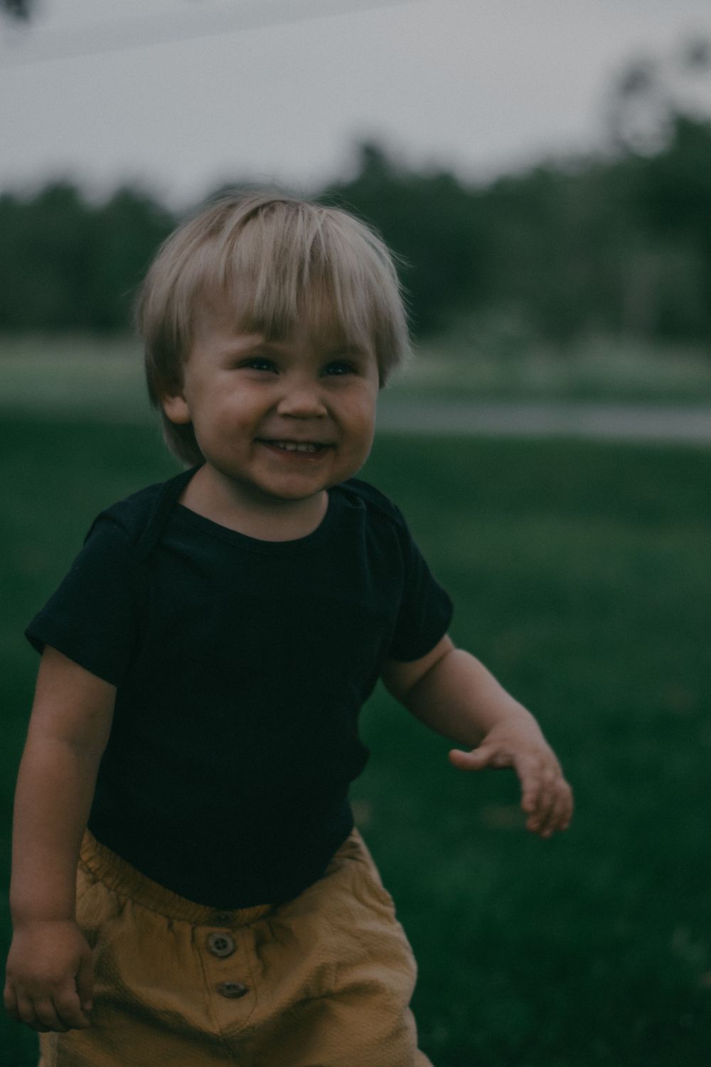 Pure joy captured during playtime outdoors in a black t-shirt.