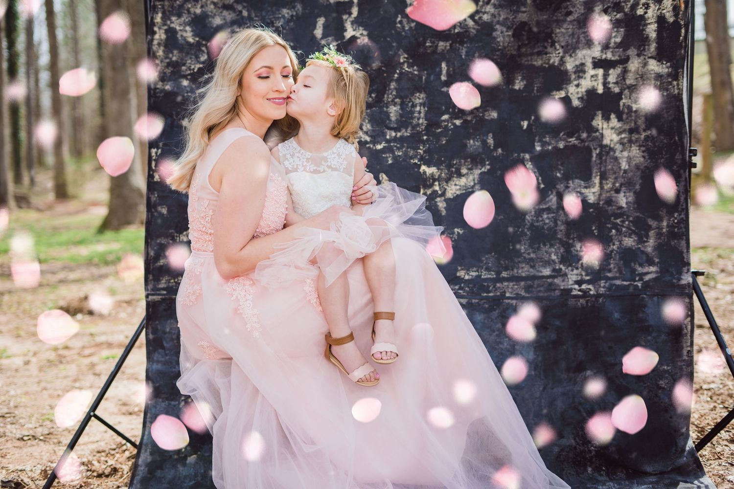 Ethereal photo with bokeh effects showing two in pink dresses against a dark backdrop.