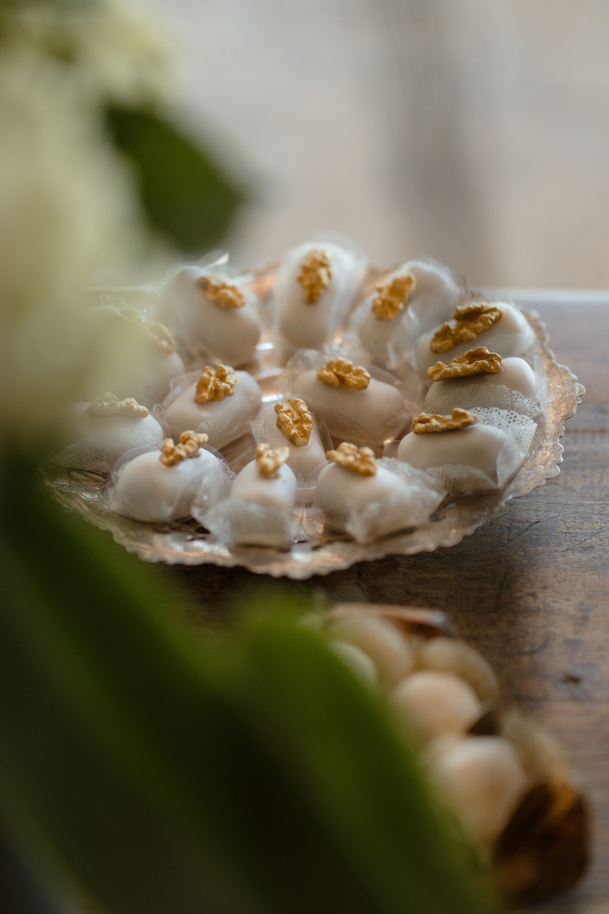 Delicate white meringue cookies with golden tops arranged on a rustic wooden surface.