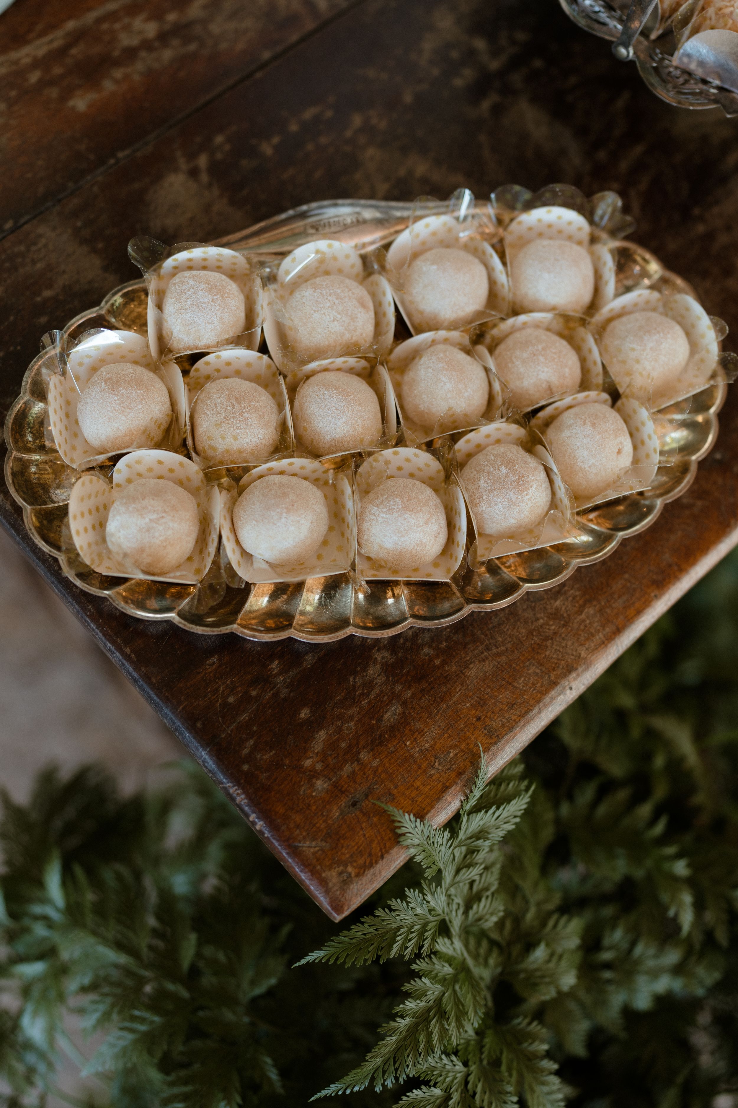 Elegant display of white macarons arranged on a vintage glass serving platter.