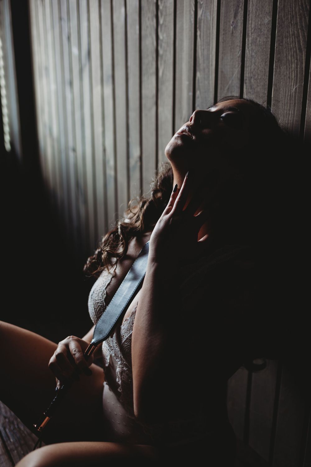 Intimate portrait session with dramatic shadows and wood panel background.