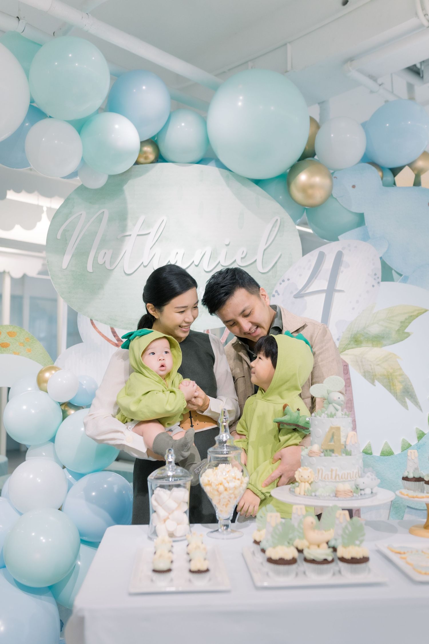 Family celebration with blue and gold balloon decorations and dessert table.