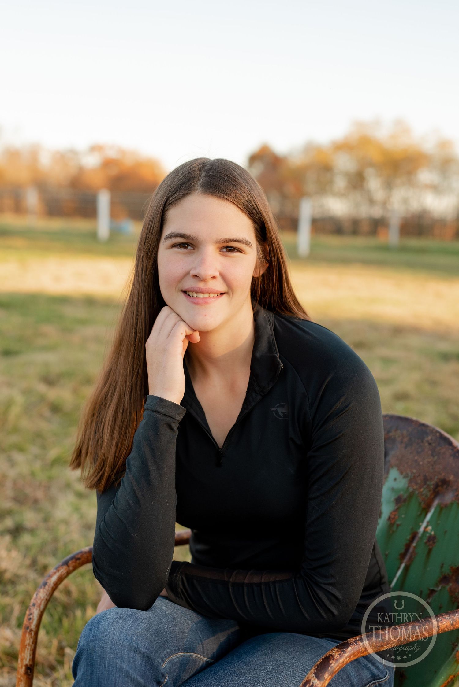Relaxed outdoor portrait on rustic chair with autumn scenery.