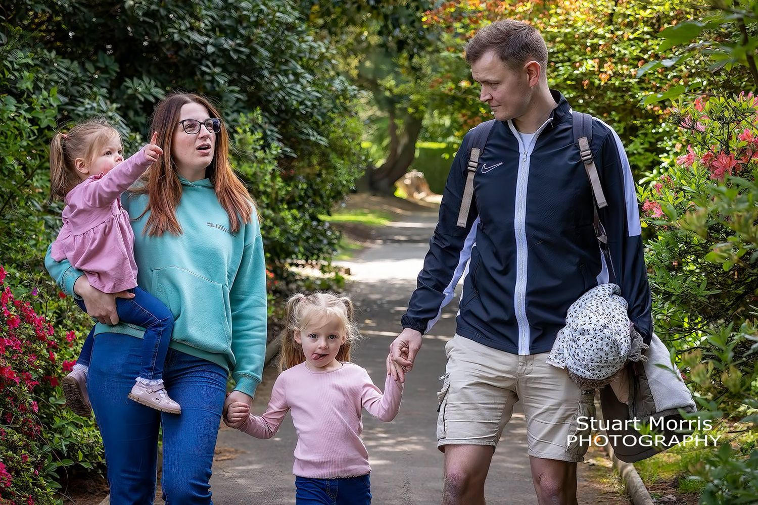 informal family outdoor portrait walking along holding hands. Walton hall gardens. Stuart Morris Photography.