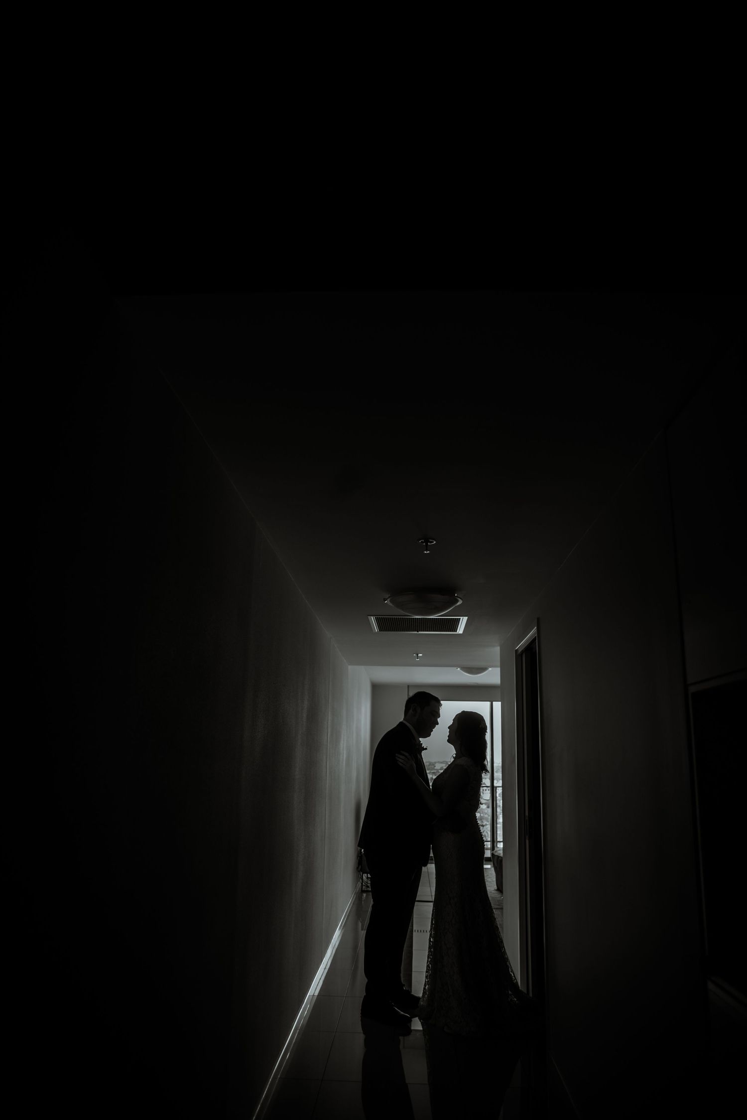 Dramatic silhouette of a couple in a dark hallway creating a romantic mood.