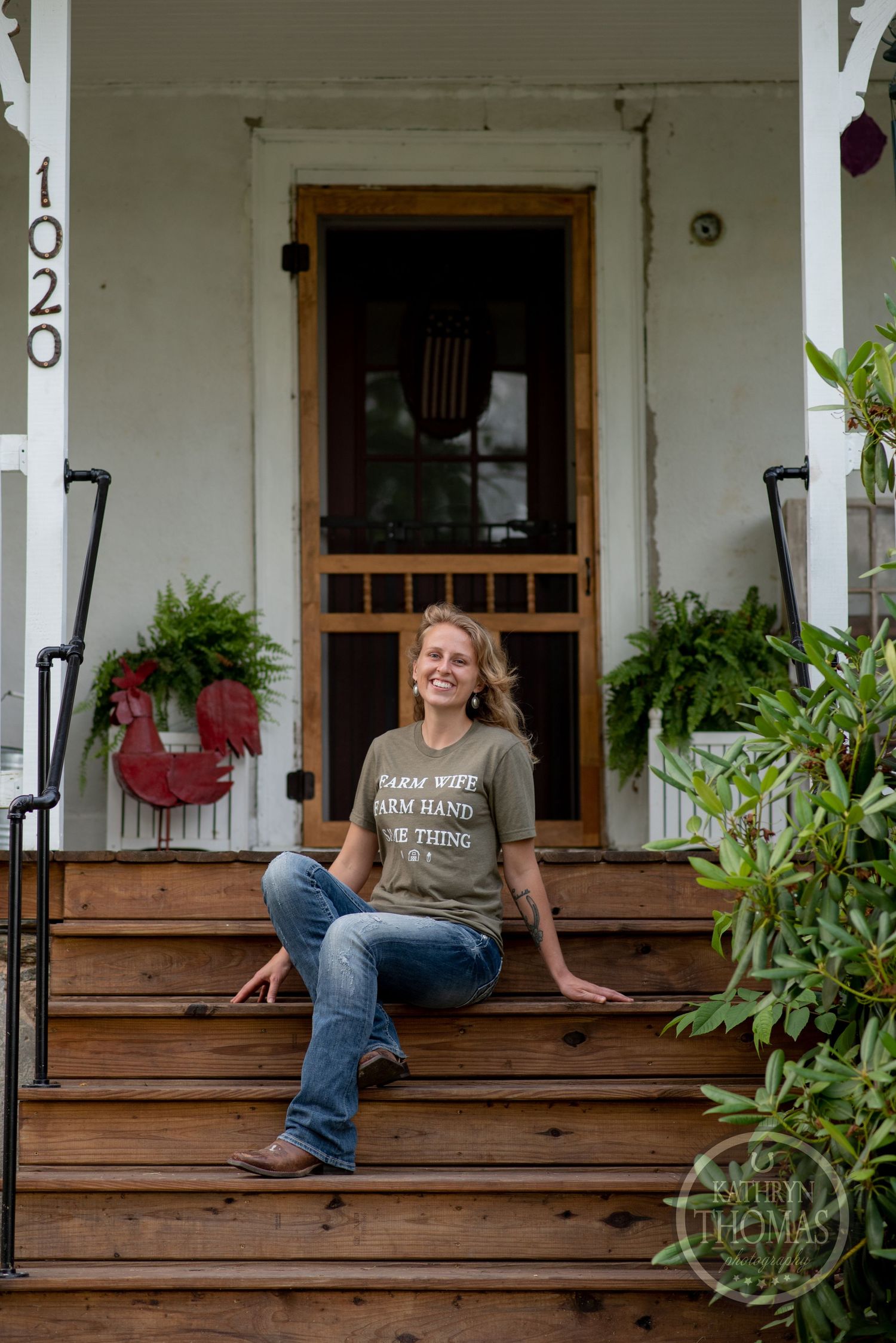 A rustic white porch entrance decorated with hanging planters and wooden steps.