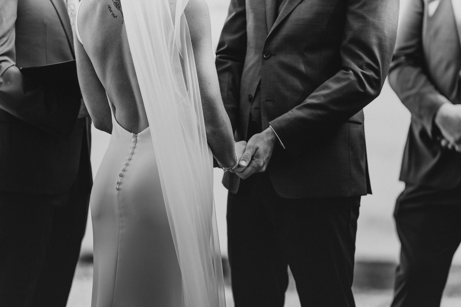 Wedding guests stand together during an outdoor ceremony celebration.