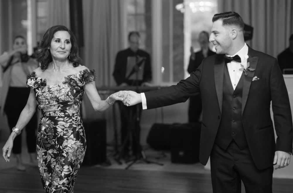 Couple dancing in formal attire at elegant ballroom reception.