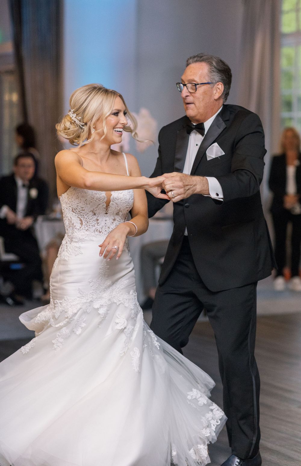 Joyful dancing moment at elegant wedding reception.